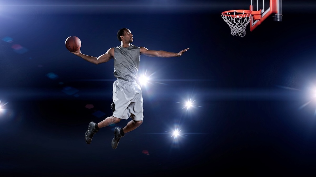 Basketball Player Poised For A Slam Dunk, Illuminated By LED RGB Arena Lighting
